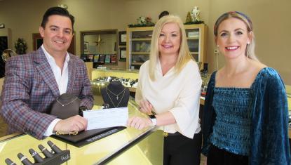 Jacqueline's owner Tom Licciardi donates a check to the United Way